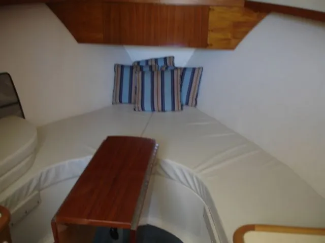 Bait's Factor Yacht Photos Pics 2002 Stolper 35 EXPRESS cabin interior with striped cushions and wooden table.