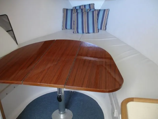Bait's Factor Yacht Photos Pics Interior of 2002 Stolper 35 EXPRESS with wooden table and striped cushions.