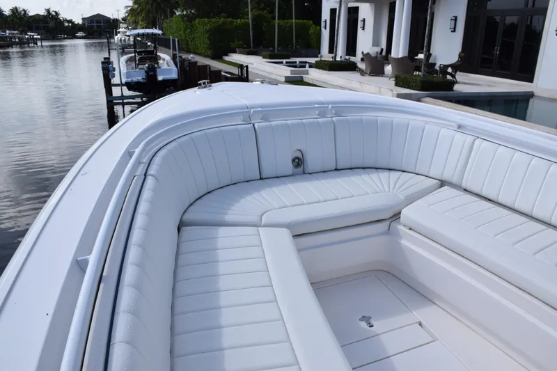  Yacht Photos Pics 2017 Intrepid 327 boat with white cushioned seating, docked by waterfront homes.
