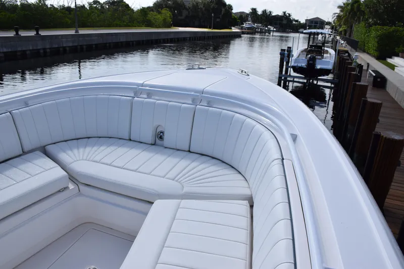  Yacht Photos Pics 2017 Intrepid 327 boat with white seating, docked by a calm canal.
