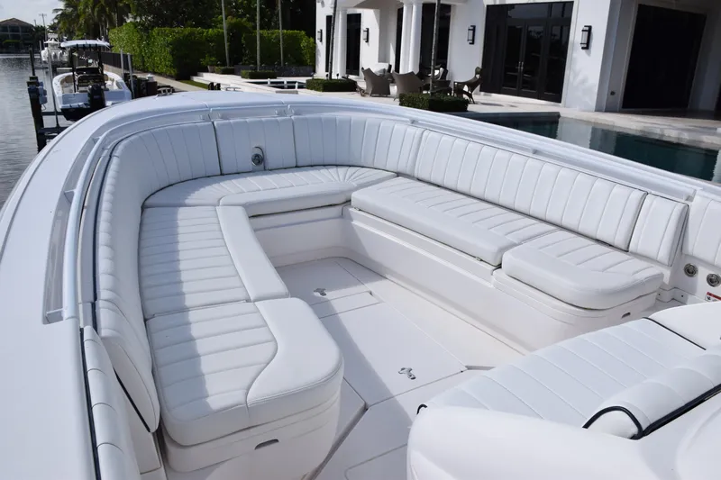  Yacht Photos Pics Luxurious seating on a 2017 Intrepid 327 boat, docked by a waterfront home.
