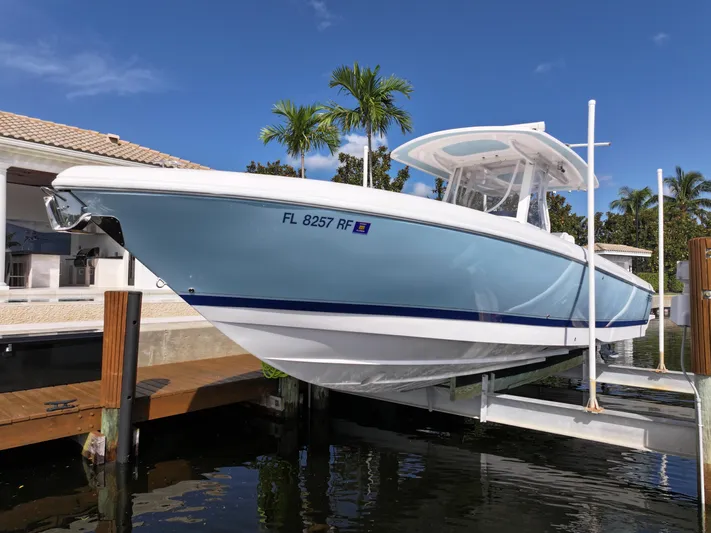  Yacht Photos Pics 2017 Intrepid 327 boat docked, light blue hull, sunny day, palm trees in background.