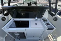 2023 Saxdor 270 GTO boat kitchen area with stove, sink, and storage.