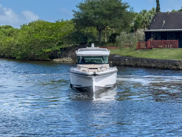  Yacht Photos Pics 2024 Axopar 37XC CROSS CABIN boat cruising on a scenic waterway.