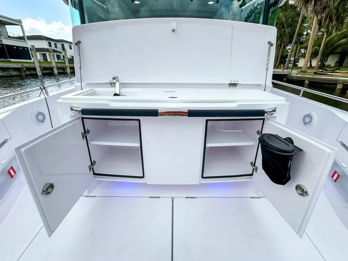  Yacht Photos Pics 2024 Axopar 37XC CROSS CABIN boat interior with open storage compartments and sink.