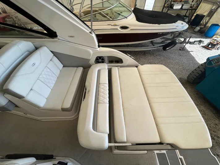  Yacht Photos Pics 2021 Regal 2800 Express boat interior with white cushioned seating in a garage.