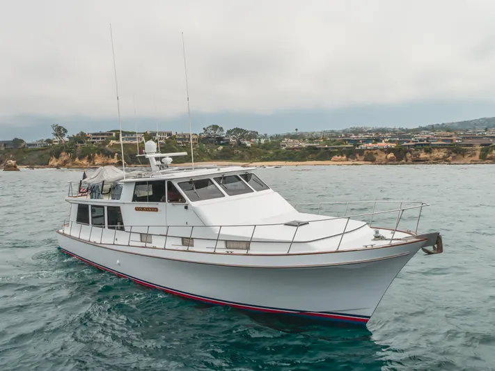 Vin Santo Yacht Photos Pics 1984 Vic Franck pilothouse yacht cruising near coastal cliffs.