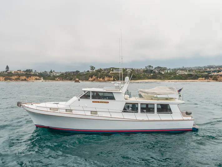 Vin Santo Yacht Photos Pics 1984 Vic Franck pilothouse yacht cruising near a scenic coastline.