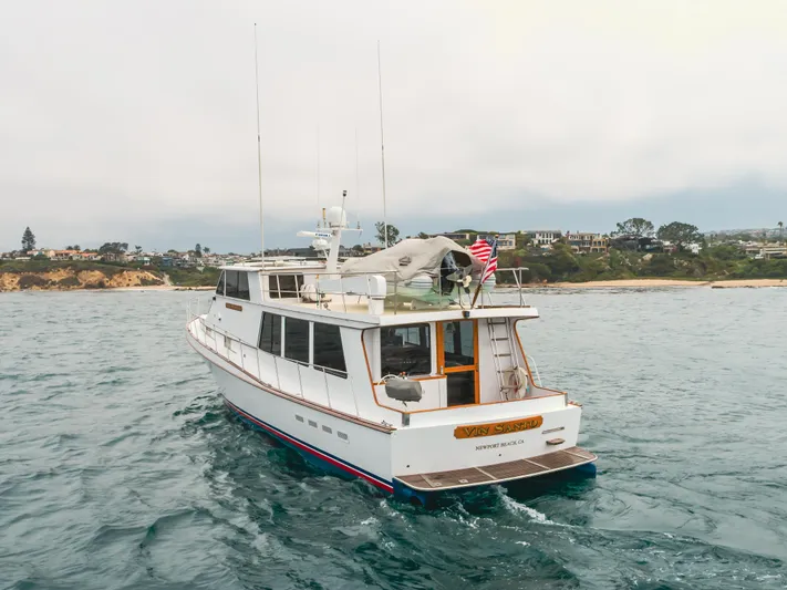 Vin Santo Yacht Photos Pics 1984 Vic Franck pilothouse yacht cruising near a scenic coastline.