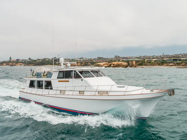 Vin Santo Yacht Photos Pics 1984 Vic Franck pilothouse yacht cruising on the ocean near rocky coastline.