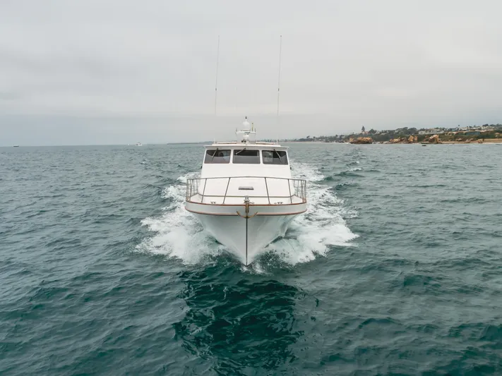 Vin Santo Yacht Photos Pics 1984 Vic Franck pilothouse yacht cruising on open sea with coastal background.