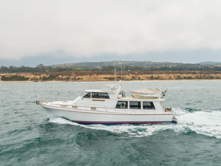 Vin Santo Yacht Photos Pics 1984 Vic Franck pilothouse yacht cruising on the ocean near a scenic coastline.
