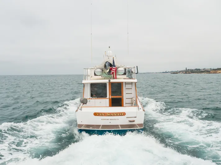Vin Santo Yacht Photos Pics 1984 Vic Franck pilothouse boat cruising on open water, rear view.