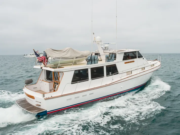 Vin Santo Yacht Photos Pics 1984 Vic Franck pilothouse yacht cruising on open water, featuring sleek design and American flag.