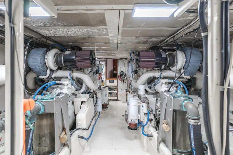Vin Santo Yacht Photos Pics Engine room of a 1984 Vic Franck pilothouse yacht, showcasing dual engines and mechanical systems.