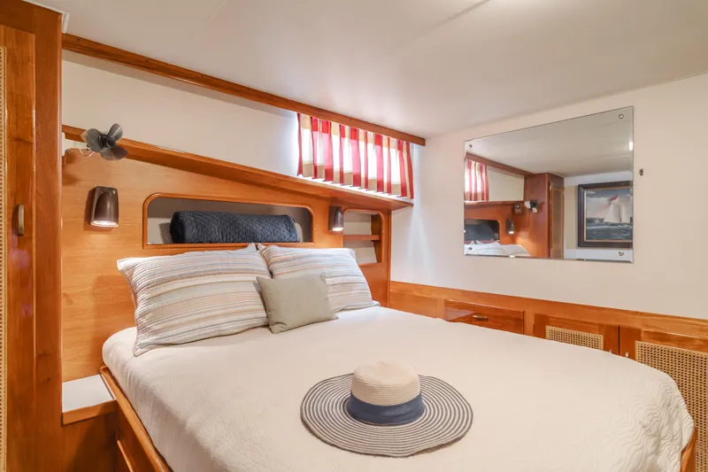 Vin Santo Yacht Photos Pics Cozy bedroom in 1984 Vic Franck pilothouse yacht with striped curtains and nautical decor.