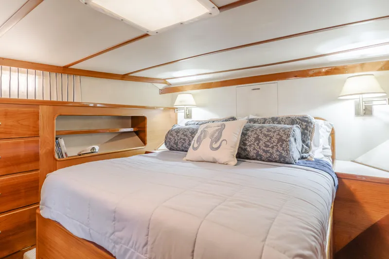 Vin Santo Yacht Photos Pics Luxurious 1984 Vic Franck pilothouse bedroom with elegant wood finish and cozy bedding.