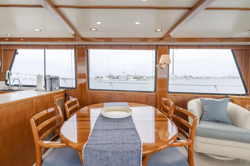 Vin Santo Yacht Photos Pics Luxurious 1984 Vic Franck pilothouse interior with wooden dining table and panoramic windows.