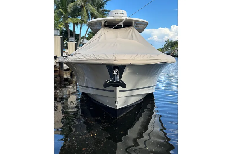  Yacht Photos Pics 2020 Boston Whaler 330 Outrage boat docked, covered, with palm trees in the background.