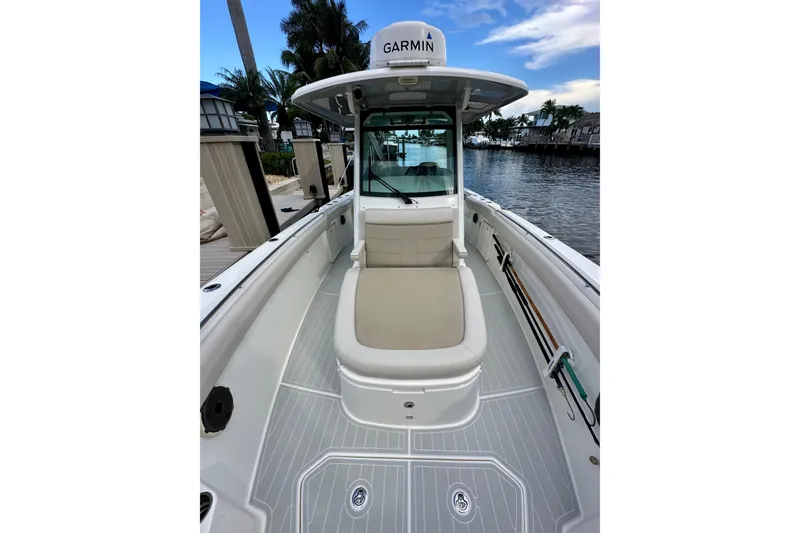  Yacht Photos Pics 2020 Boston Whaler 330 Outrage boat interior with Garmin equipment, docked by a waterfront.