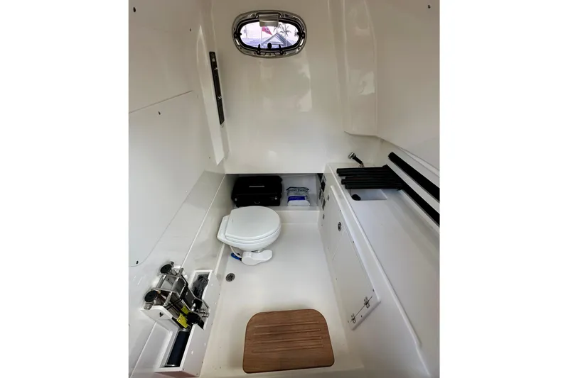  Yacht Photos Pics 2020 Boston Whaler 330 Outrage cabin interior with toilet and storage compartments.