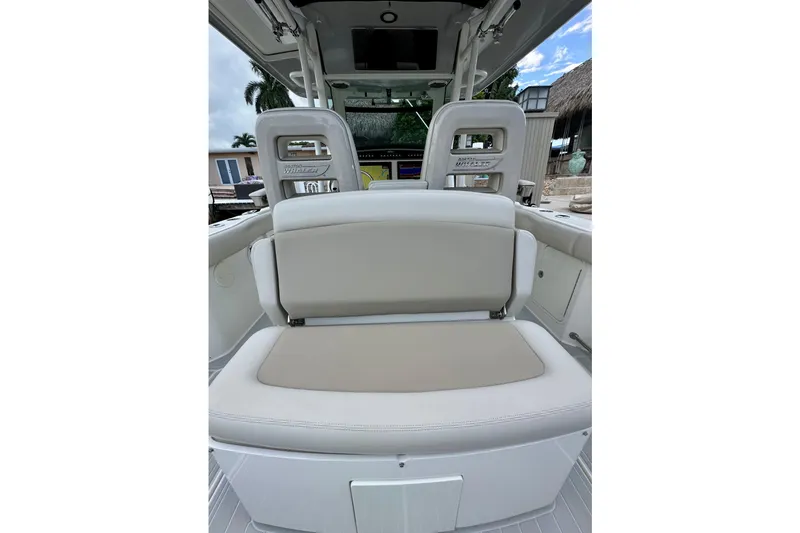  Yacht Photos Pics 2020 Boston Whaler 330 Outrage boat interior with cushioned seating and helm station.