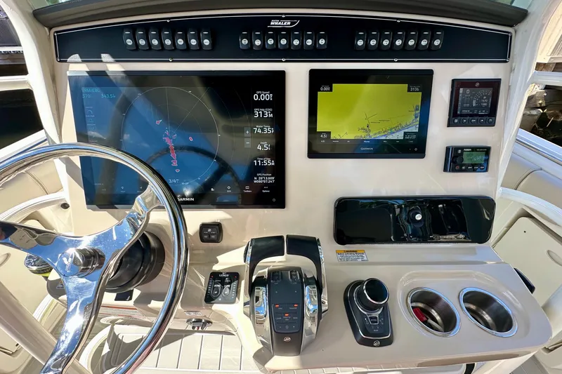  Yacht Photos Pics Control panel of 2020 Boston Whaler 330 Outrage with navigation screens and steering wheel.