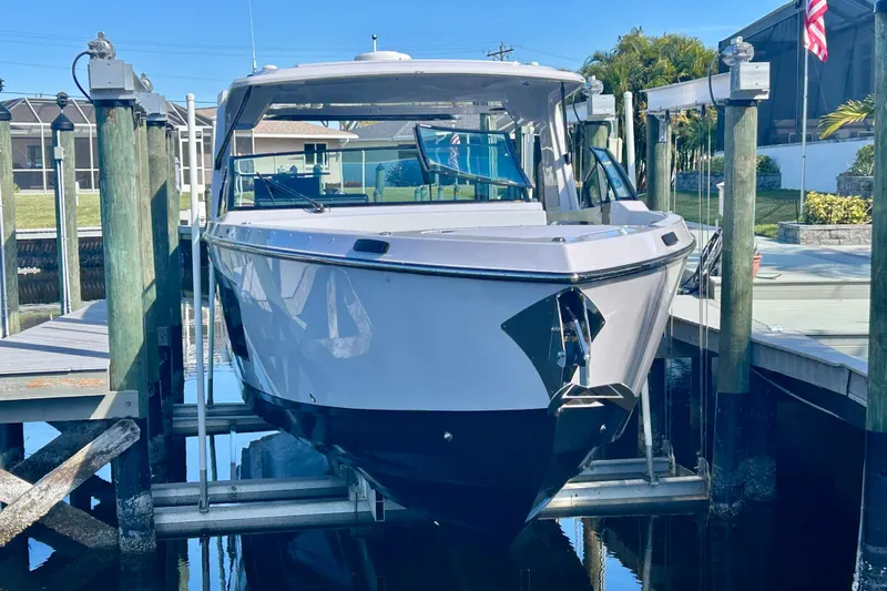 Happy Our II Yacht Photos Pics 2022 Aviara AV40 OB boat docked on a lift, surrounded by wooden piers.
