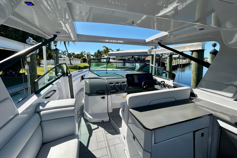 Happy Our II Yacht Photos Pics 2022 Aviara AV40 OB luxury boat interior with modern helm and seating, docked by a serene waterfront.