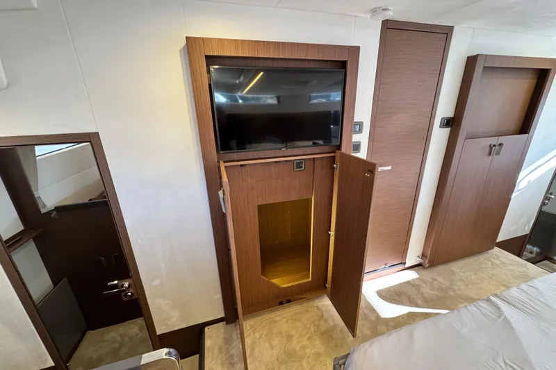  Yacht Photos Pics 2024 Prestige M48 yacht interior with wooden cabinetry and built-in TV.