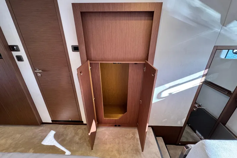  Yacht Photos Pics Open wooden cabinet in 2024 Prestige M48 interior, showcasing sleek design and ample storage.