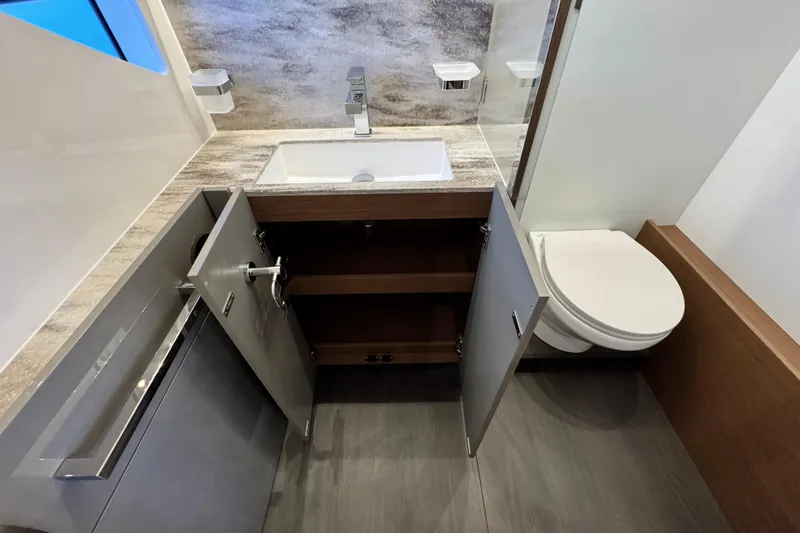  Yacht Photos Pics Modern bathroom in 2024 Prestige M48 yacht with sink, toilet, and open cabinet.