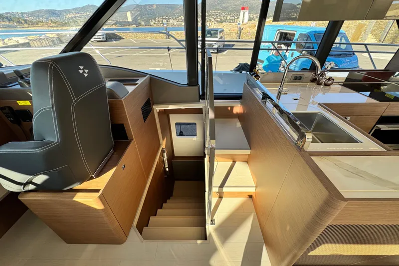  Yacht Photos Pics Interior of 2024 Prestige M48 yacht featuring helm, stairs, and modern kitchen area.