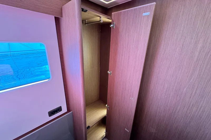 Yacht Photos Pics 2024 Prestige M48 yacht interior with open wooden closet and window view.