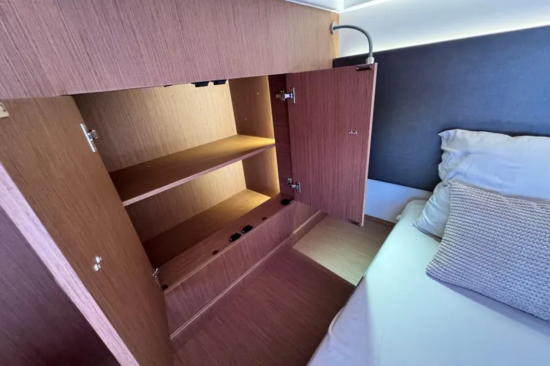  Yacht Photos Pics Open wooden cabinet in Prestige M48 yacht bedroom, 2024 model, with bed and pillow nearby.