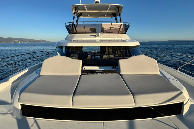  Yacht Photos Pics 2024 Prestige M48 yacht with sun loungers on deck, cruising in calm waters.