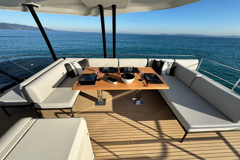  Yacht Photos Pics Luxurious 2024 Prestige M48 yacht deck with elegant dining setup and ocean view.