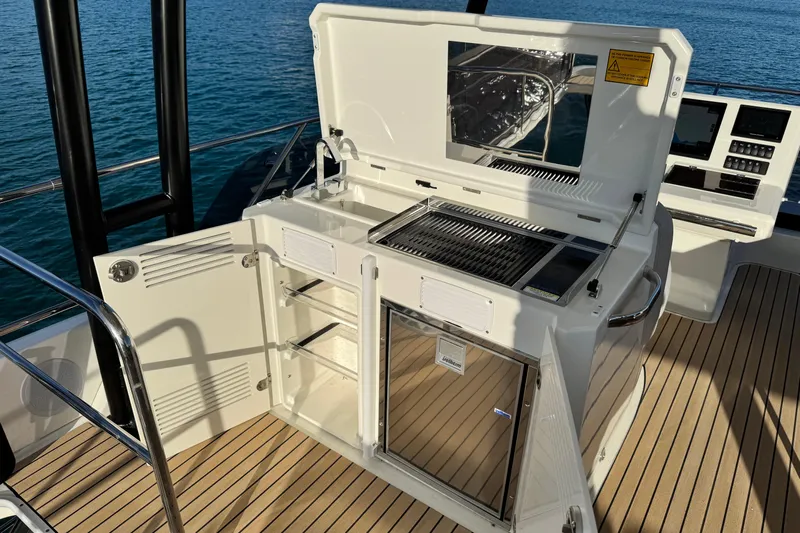  Yacht Photos Pics Outdoor kitchen on 2024 Prestige M48 yacht with grill and storage, overlooking the ocean.