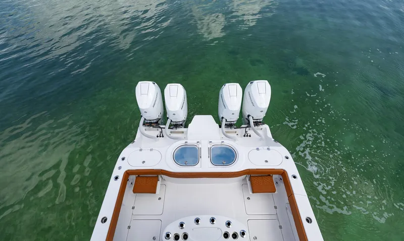  Yacht Photos Pics 2023 Invincible 46 Pilothouse boat with four powerful outboard engines on clear water.