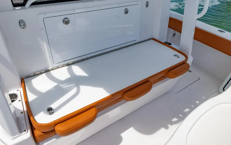  Yacht Photos Pics 2023 Invincible 46 Pilothouse boat seating area with orange accents and storage compartment.