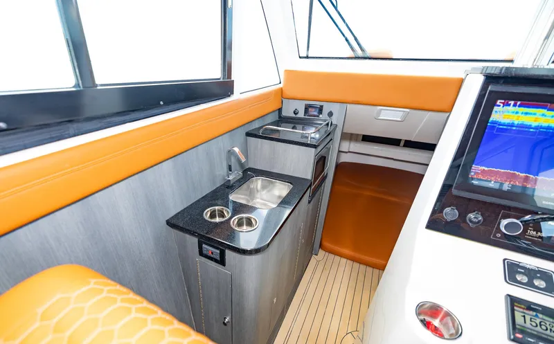  Yacht Photos Pics 2023 Invincible 46 Pilothouse interior with kitchenette and navigation display.