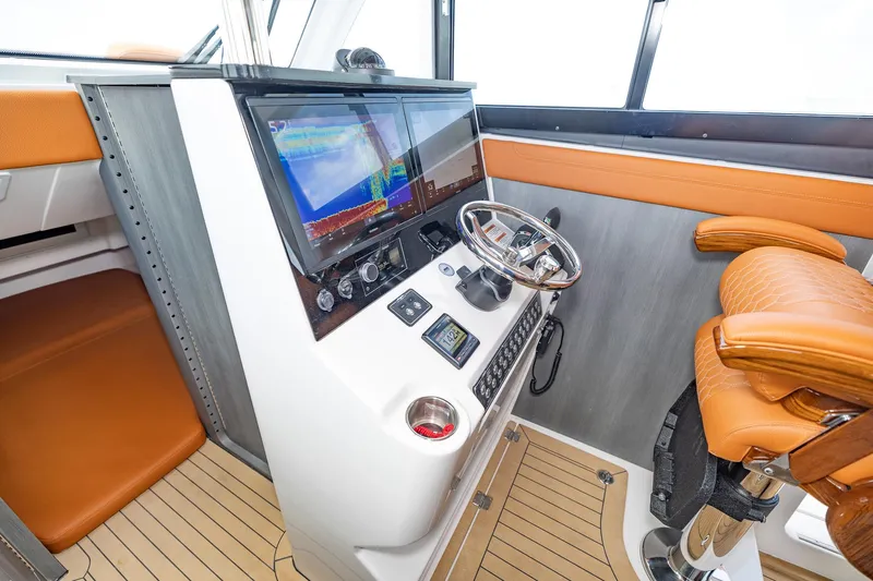  Yacht Photos Pics 2023 Invincible 46 Pilothouse helm with modern navigation system and leather seating.