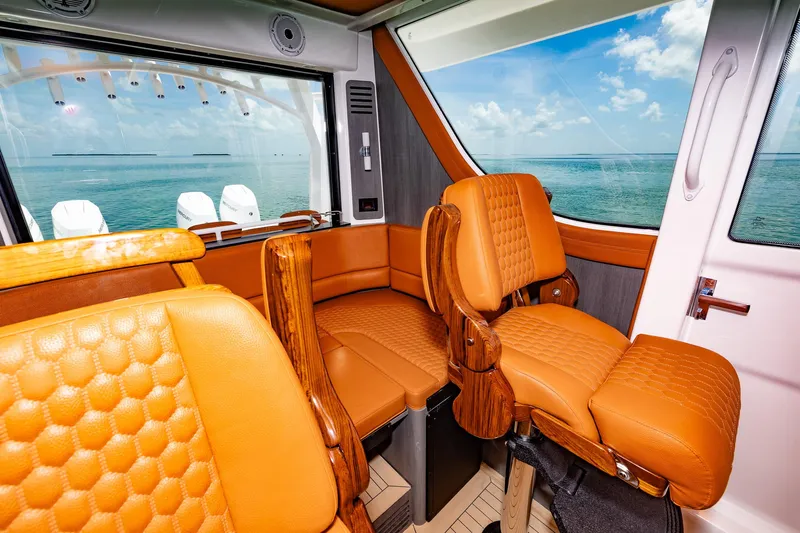 Yacht Photos Pics Luxurious interior of 2023 Invincible 46 Pilothouse with orange leather seating and ocean view.