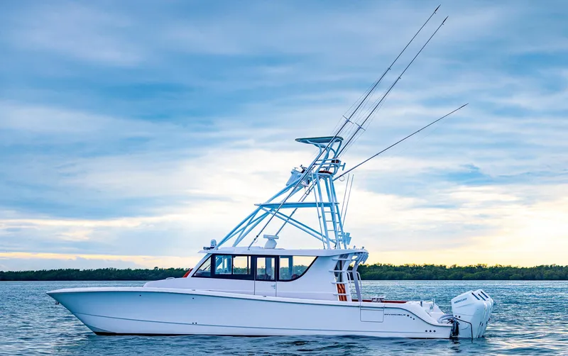  Yacht Photos Pics 2023 Invincible 46 Pilothouse boat on calm water under a cloudy sky.