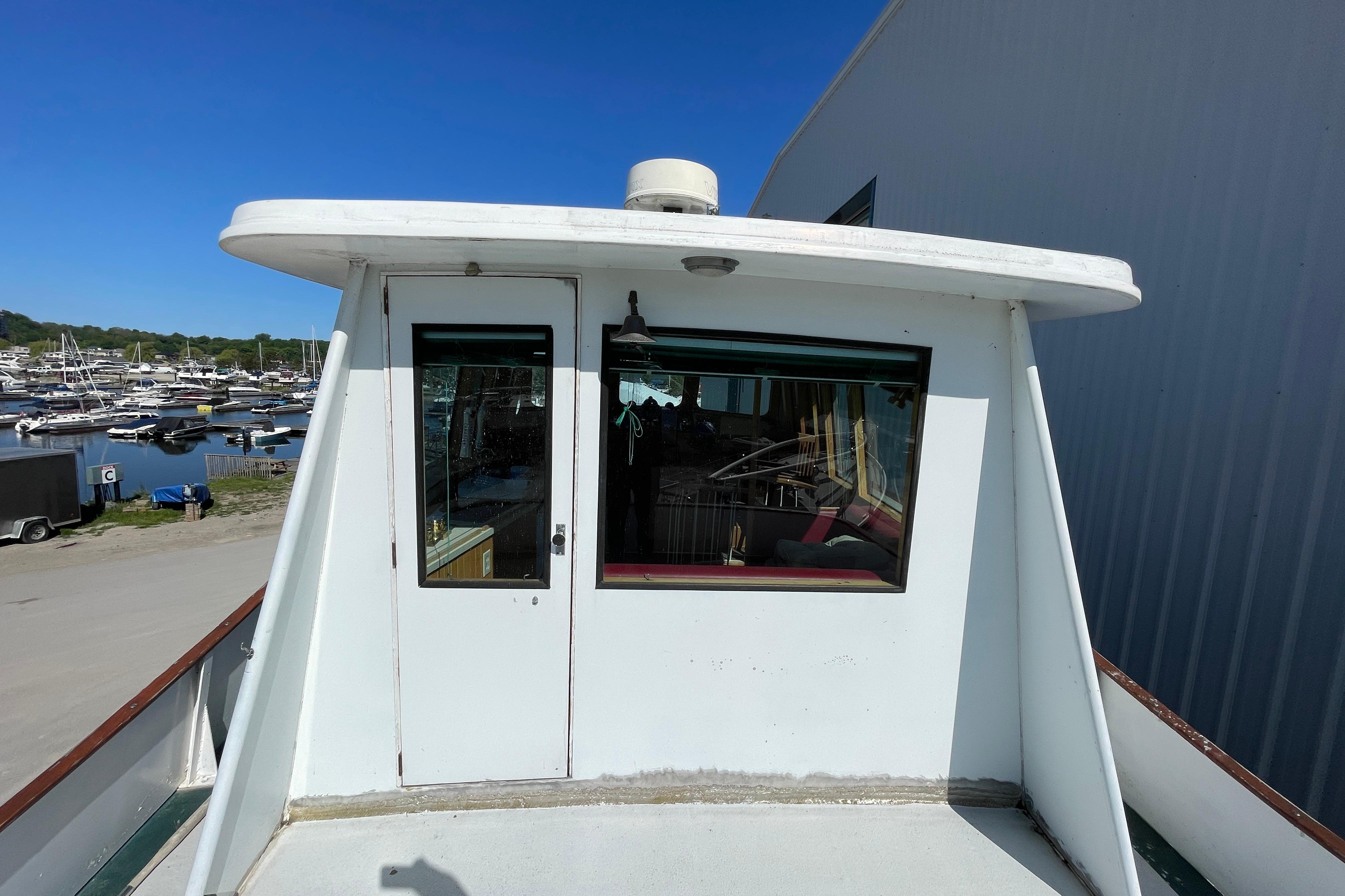 1966 Vinette 430 Trawler docked, showcasing cabin exterior and marina view.
