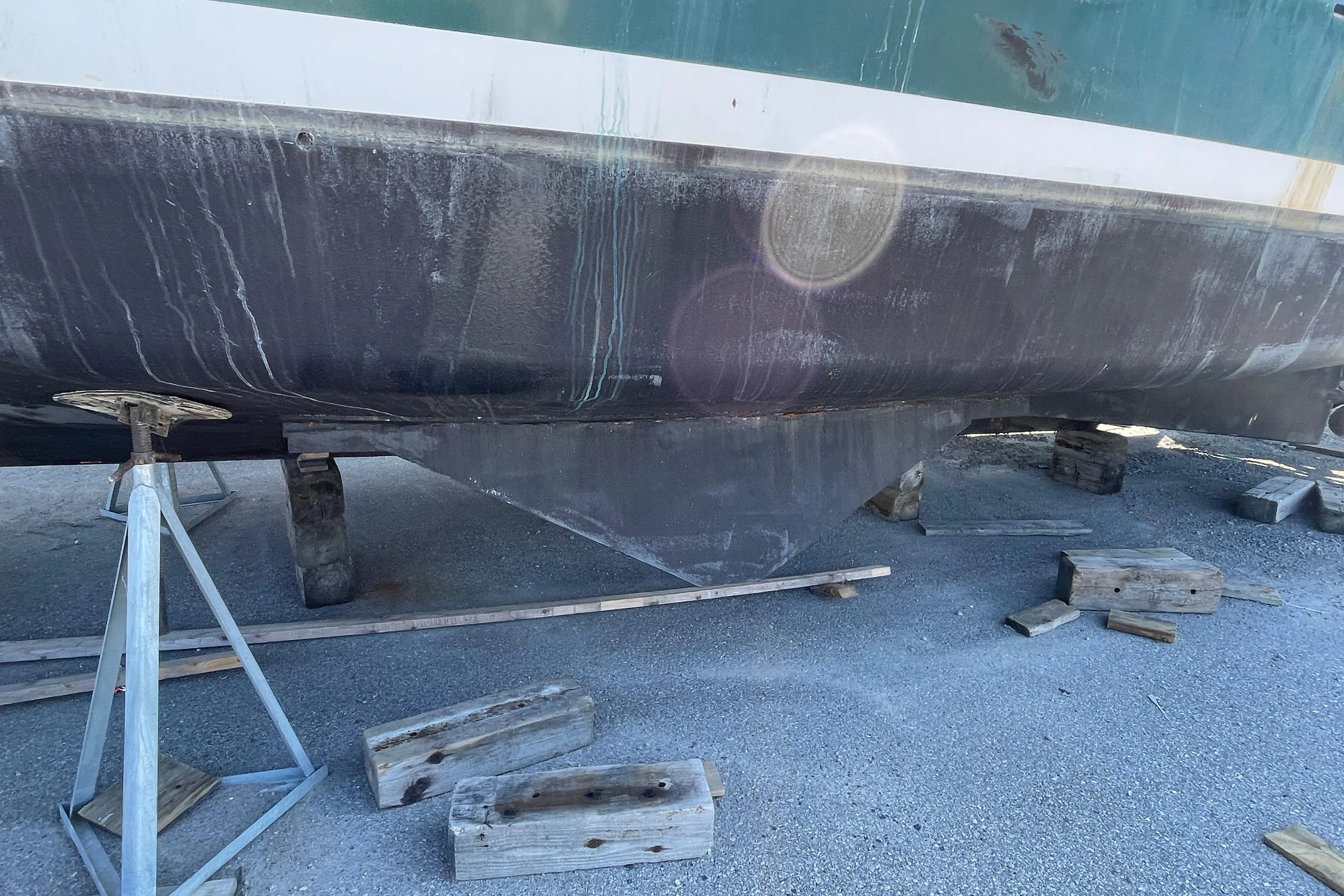 1966 Vinette 430 Trawler hull on dry dock with wooden supports.