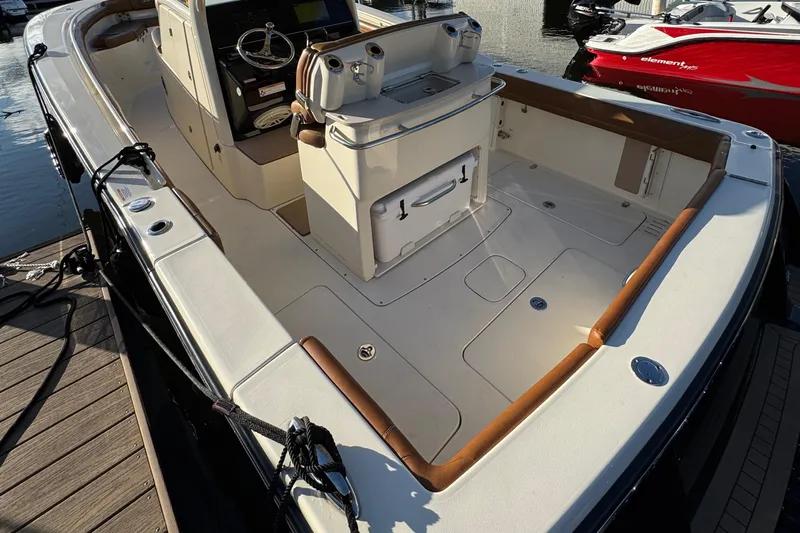  Yacht Photos Pics 2018 Scout 300 LXF boat interior, featuring helm and seating area at dock.