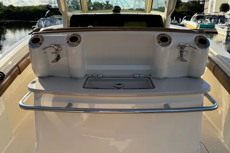  Yacht Photos Pics 2018 Scout 300 LXF boat console with rod holders and storage compartment.
