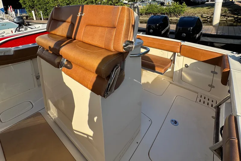  Yacht Photos Pics 2018 Scout 300 LXF boat interior with tan leather seating and helm station.