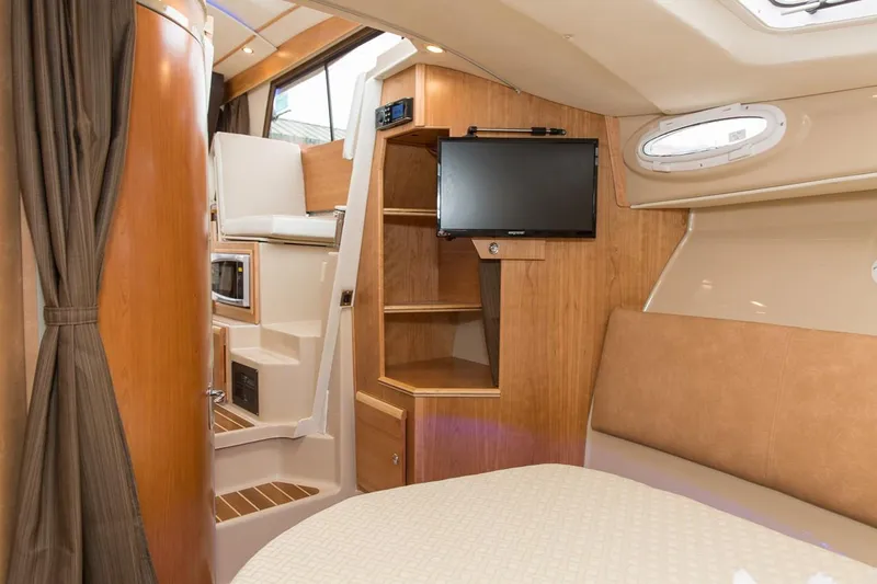 Ruff Life Yacht Photos Pics Manufacturer Provided Image: Interior of 2022 Cutwater C-30 Sedan boat with TV, wood cabinetry, and seating area.